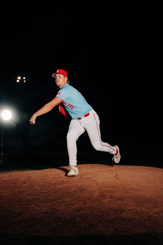 An Abbotsford Cardinals pitcher follows through on the mound at night.
