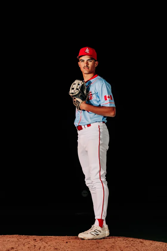 An Abbotsford Cardinals pitcher stands ready on the mound in a night portrait.